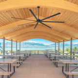Large black industrial ceiling fan installed in an outdoor pavilion