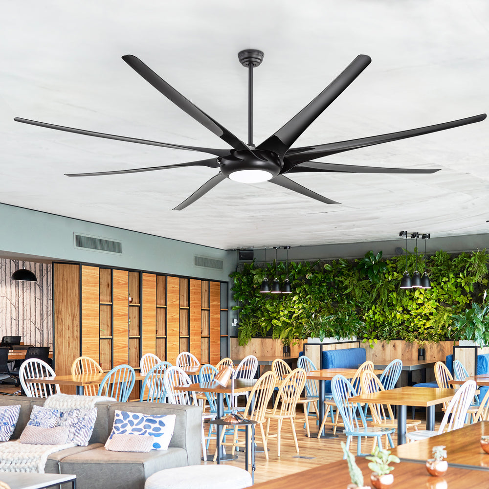 AeroSpan-XL large black ceiling fan with integrated LED light installed in a modern restaurant